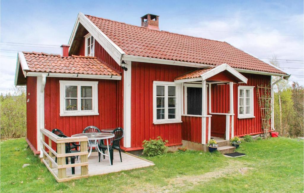 una casa rossa con un tavolo di fronte di Lovely Home In Hrryda With Kitchen a Hindås