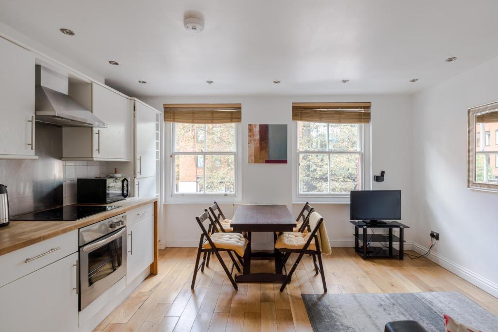 a kitchen and dining room with a table and chairs at A Midtown Minute - Holborn - by Frankie Says in London