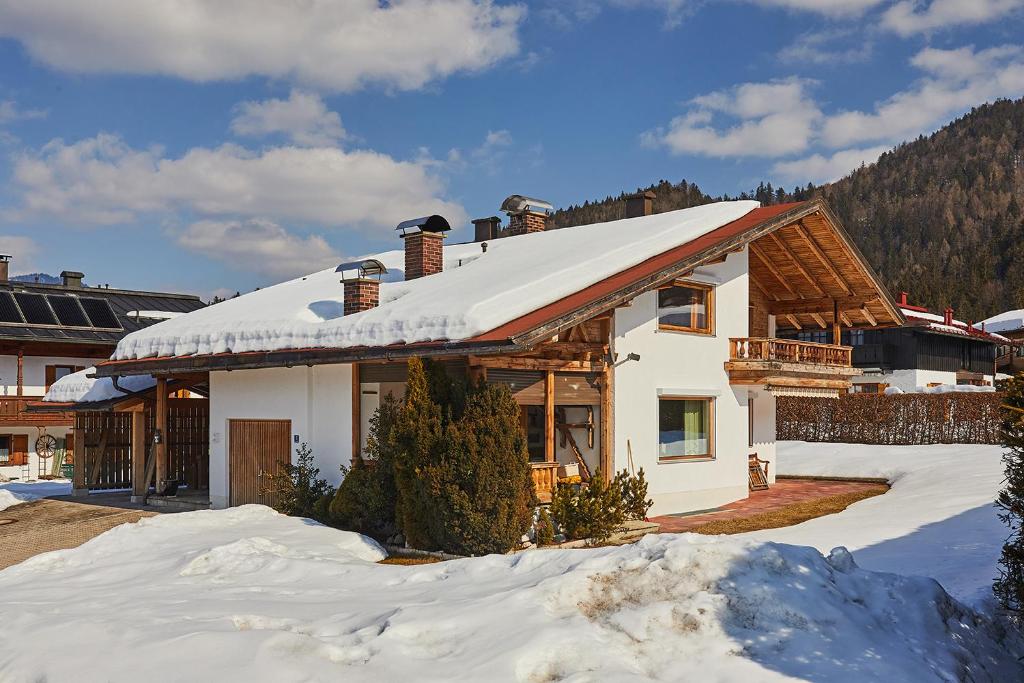 a house with snow on the roof at Alpen-Chalet Benzeck in Reit im Winkl