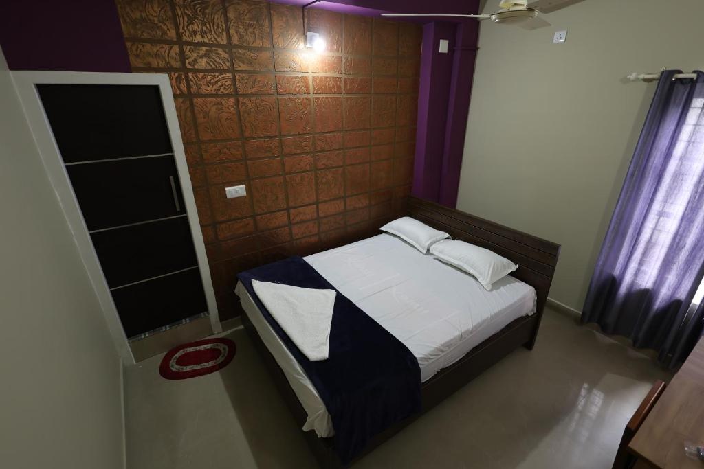 - une petite chambre avec un lit et une fenêtre dans l'établissement Wayanad regal residency, à Kalpatta