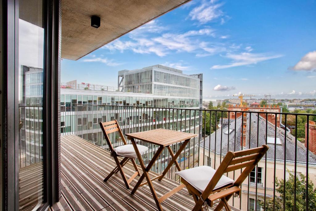 d'un balcon avec une table et deux chaises et une vue. dans l'établissement Escapade sur l'île de Nantes, à Nantes