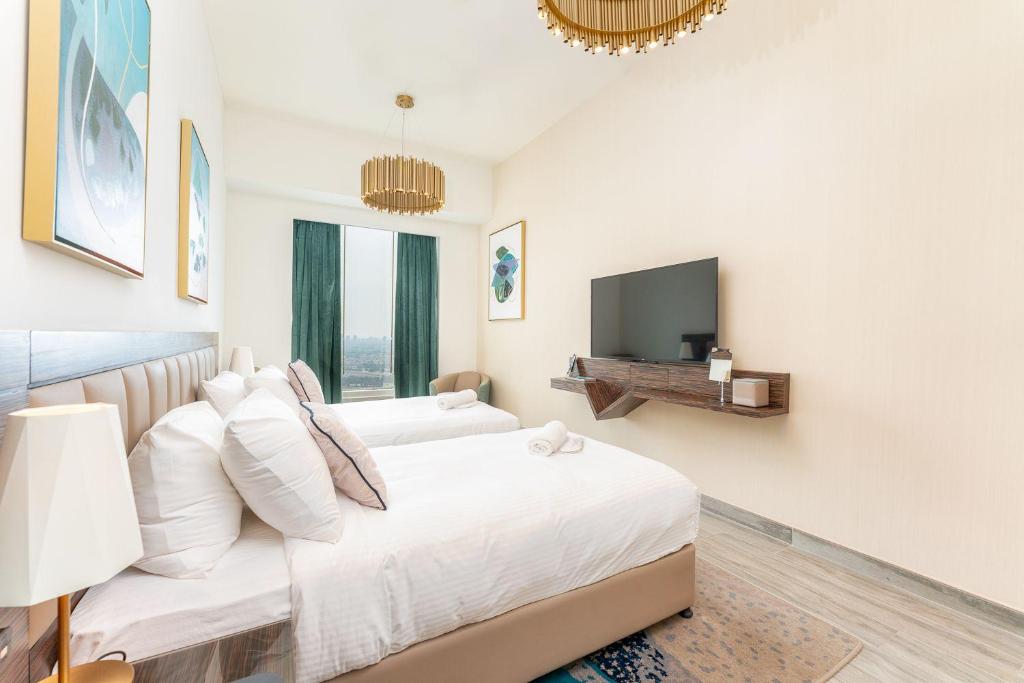 Fanciable 2BR Apartment & 1 Maids room in Avani Tower في دبي: غرفة نوم بيضاء مع سرير وتلفزيون بشاشة مسطحة