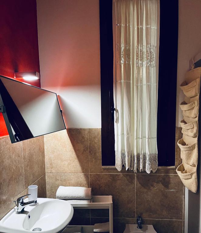 łazienka z białą umywalką i oknem w obiekcie Sicilia Vacation rooms w Trapani