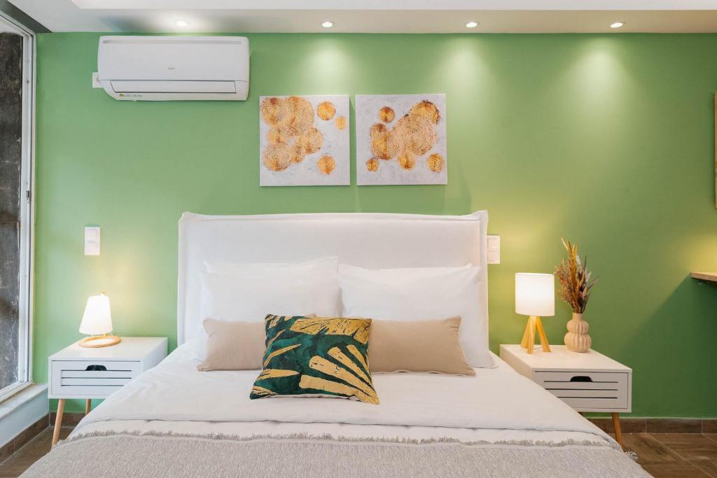 um quarto com uma cama branca e uma parede verde em Phaedrus Living: The Emerald Studio em Atenas