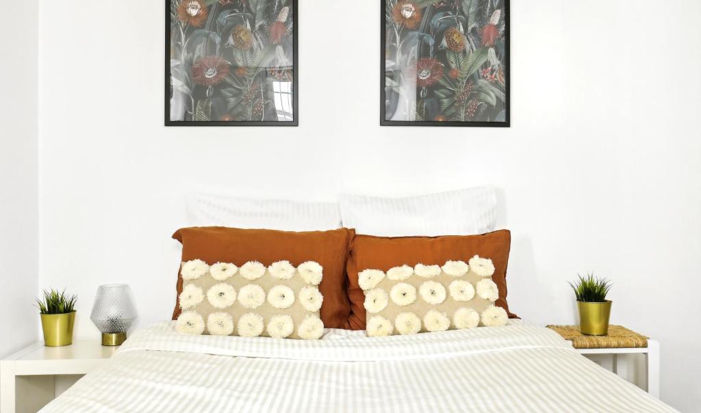 ein Schlafzimmer mit einem weißen Bett und braunen Kissen in der Unterkunft Plisson - Peaceful apartment near metro in Saint-Mandé