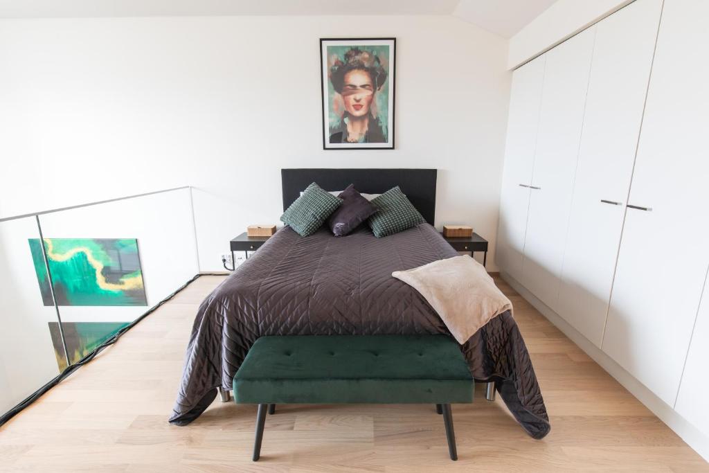 a bedroom with a bed with a green ottoman at Isla Homes - Suite, Supermarket & Alko in Tampere