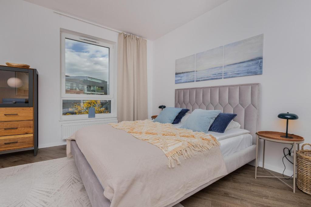 a white bedroom with a bed and a window at Śląska Studio with Parking & Gym Business District Gdańsk by Renters in Gdańsk