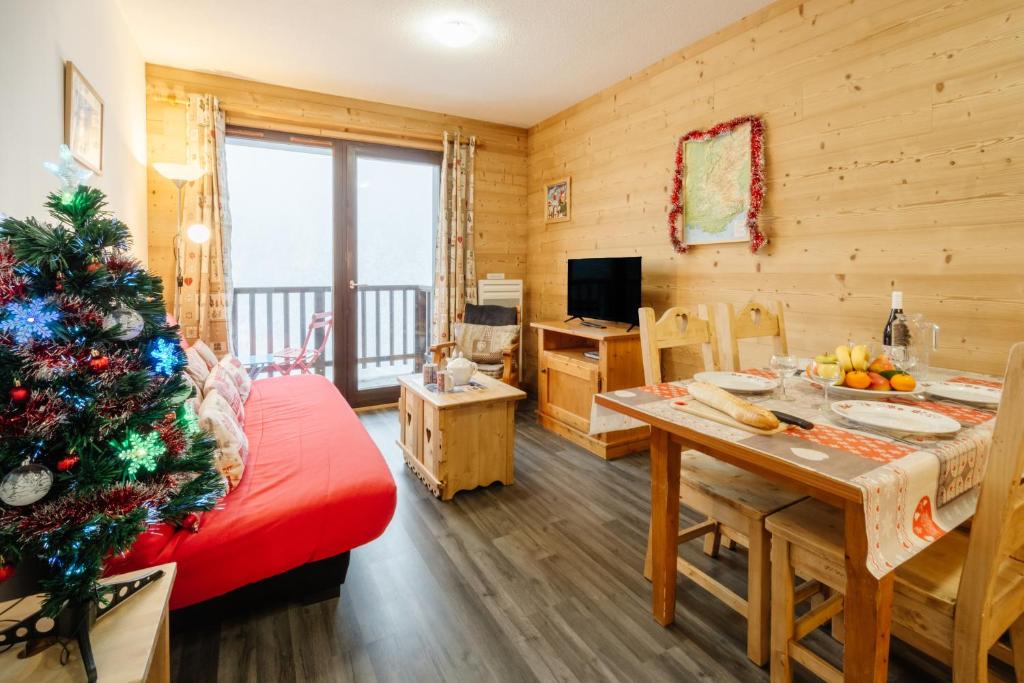 uma sala de estar com uma árvore de Natal num quarto em Le Petit Bonheur em Modane