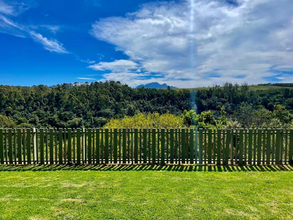 a fence in a yard with a view of the mountains at Hilltop 39, Oubaai Golf Estate in Herolds Bay