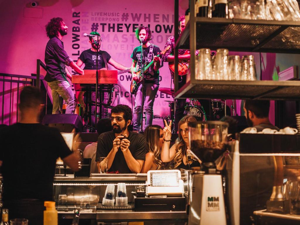 een groep mensen in een bar met een band op een podium bij YellowSquare Rome in Rome