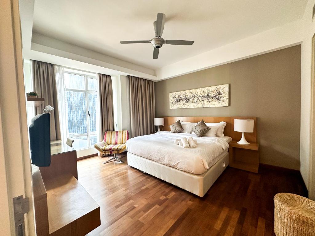 Cormar KLCC Suites By NHB في كوالالمبور: غرفة نوم بسرير ومروحة سقف