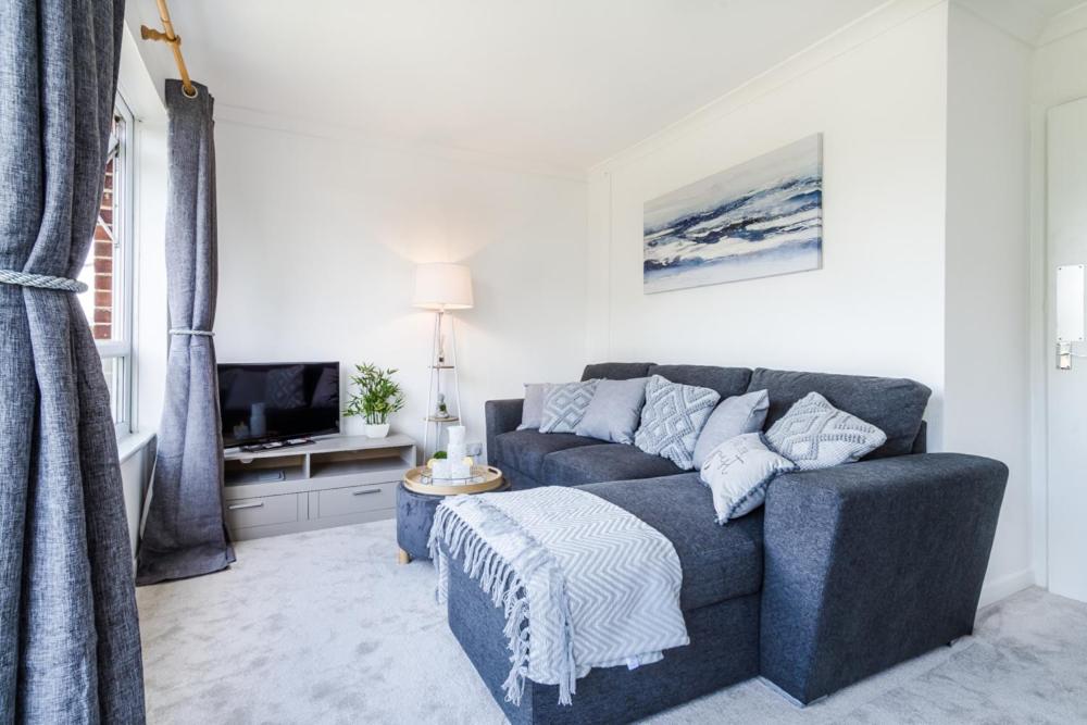 sala de estar con sofá y TV en Modern & Cozy 1BR Close to Gatwick- Long Bridge en Hookwood