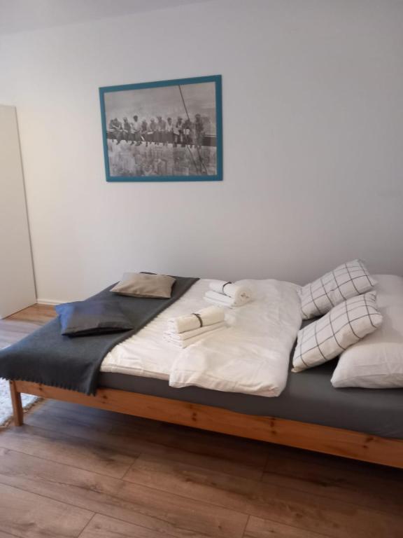 Una cama con sábanas blancas y almohadas. en Warta Piastowskie Apartament, en Poznan