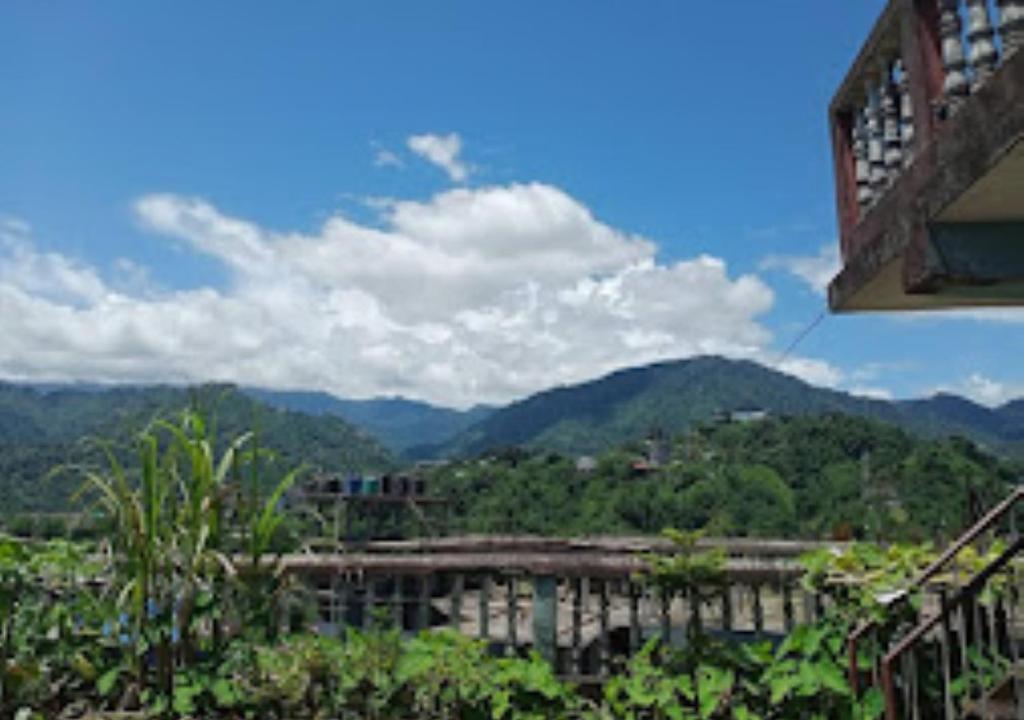 vistas a un edificio con montañas en el fondo en Hotel Blue Pine Arunachal Pradesh, en Itānagar