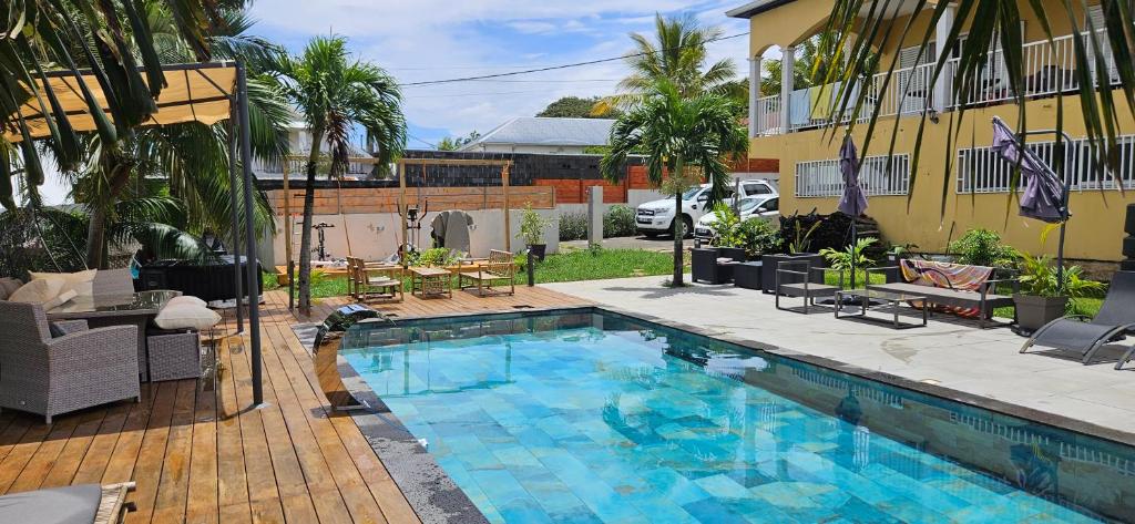 a swimming pool in front of a building at Un petit coin de paradis à La Réunion in Saint-Joseph