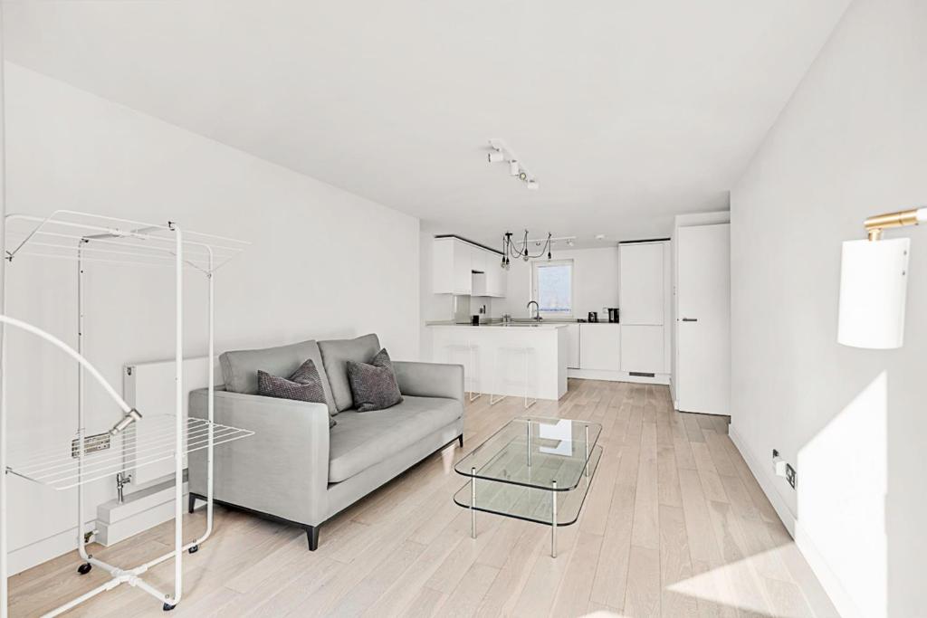 Sala de estar blanca con sofá y mesa en Radiant Chelsea Flat with City View, en Londres