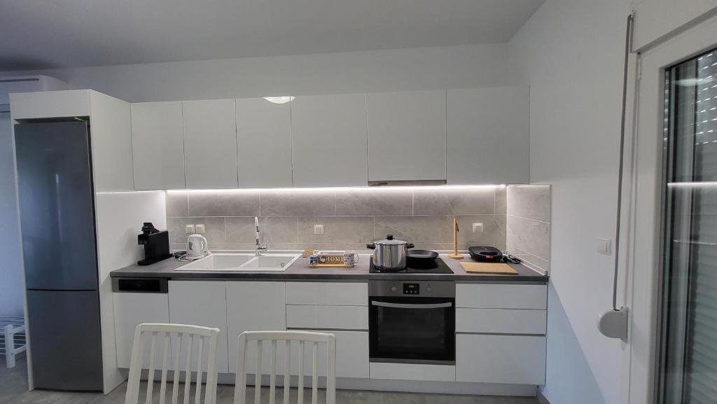 a white kitchen with a stove and a sink at Countryside apartments first floor in Tríkala