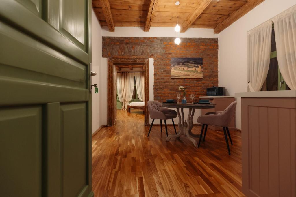 Habitación con mesa, sillas y pared de ladrillo. en Old Town Casa 1901, en Baia Mare