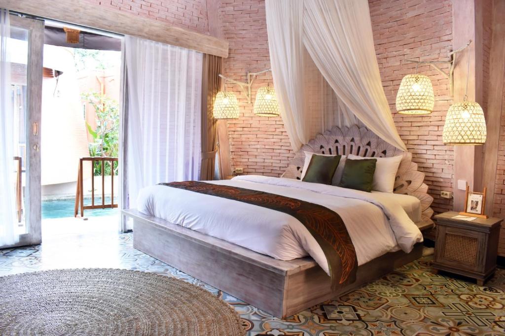 a bedroom with a large bed and a brick wall at Dusun The Villas 