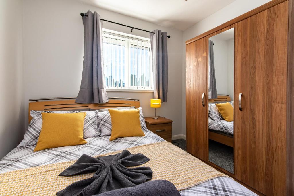 a bedroom with a bed with yellow pillows at Wealcroft House - Charming 3-Bedroom in Wealcroft in Felling