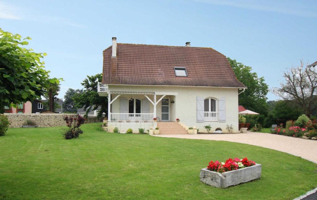 une maison blanche avec une cour verdoyante ornée de fleurs dans l'établissement Lajus fontaine, à Livron