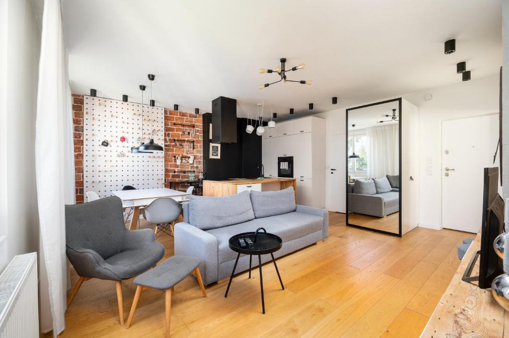 uma sala de estar com um sofá e uma mesa em Ochota Siewierska Modern Apartment em Varsóvia