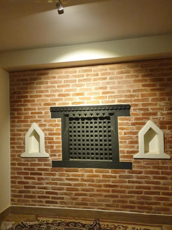 uma parede de tijolos com uma grade preta em Hiti fusa em Pātan