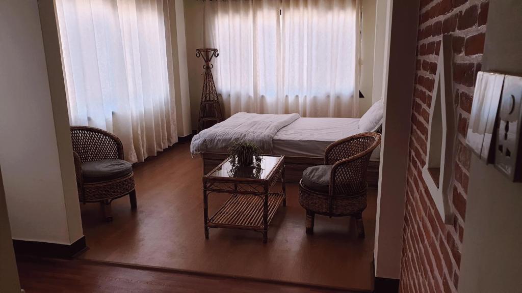 a bedroom with a bed and two chairs and a table at Hiti fusa Homestay in Pātan