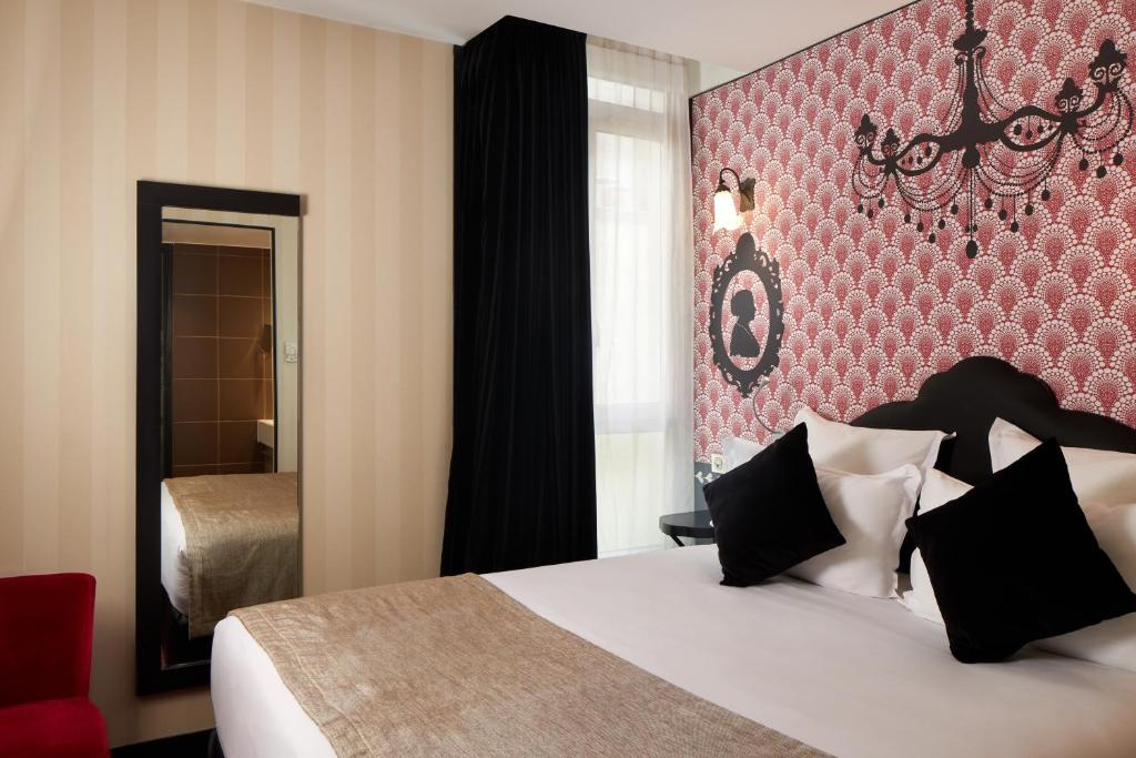 パリにあるホテル レ テアトルの赤い壁のベッドルーム1室(大型ベッド1台付)