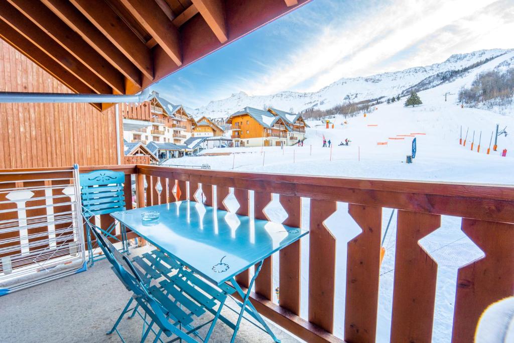 a table and chairs on a balcony with a ski slope at Sfl 1 appt 4-6 couchages in Saint-François-Longchamp