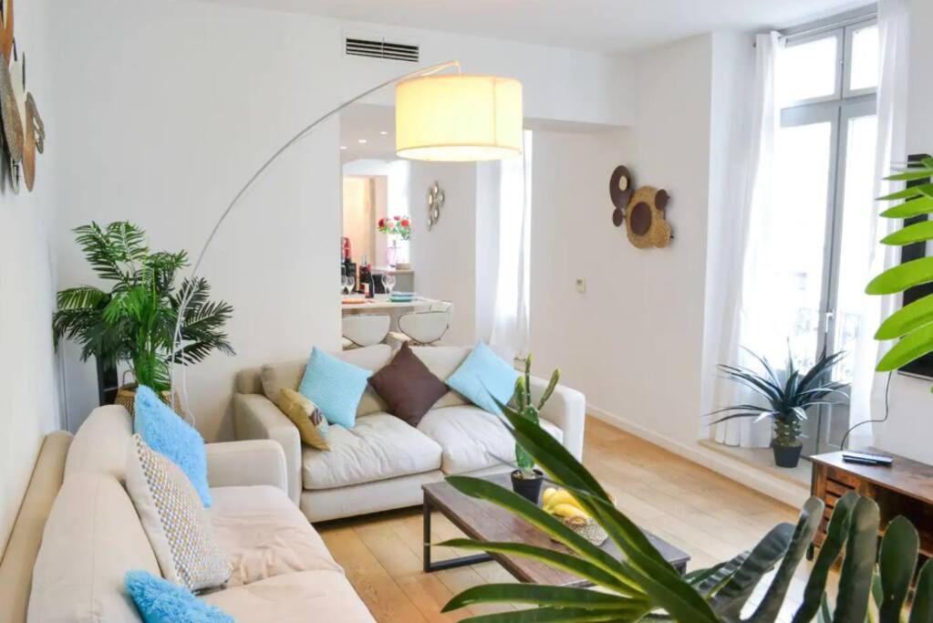 un salon avec un canapé blanc et des plantes dans l'établissement Appartement Centre-ville spacieux, élégant / Climatisation, à Montpellier