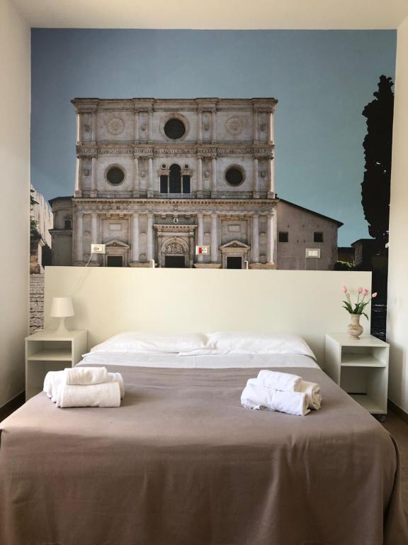 a bedroom with two towels on a bed in front of a building at Hotel Porta Rivera in LʼAquila