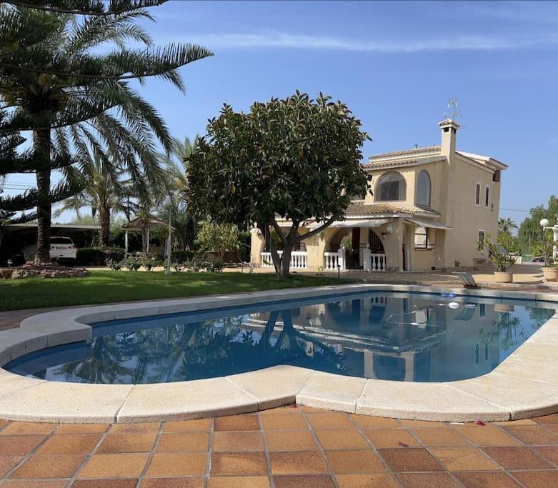 una gran piscina frente a una casa en Villa Iluminada con piscina y barbacoa cerca Playa, en Elche