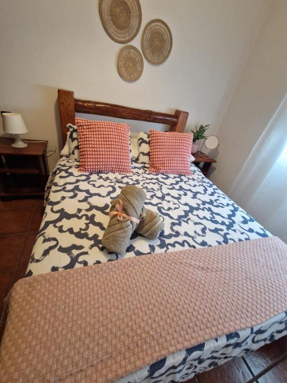 a bed with two stuffed animals sitting on it at Casa Calandrilla in Caleta de Caballo