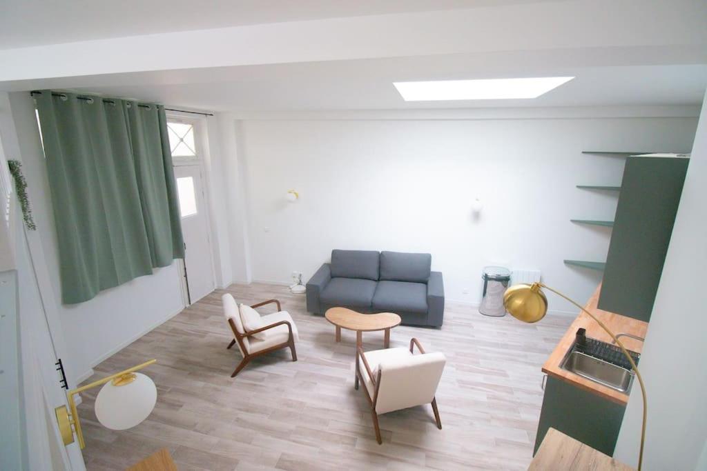 un salon avec un canapé bleu et des chaises dans l'établissement Séjournez dans un havre de paix au cœur de Paris, à Paris