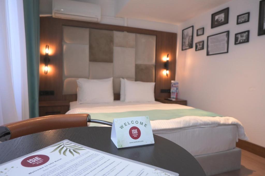 um quarto de hotel com uma cama e uma mesa com um livro em Isle Hotel em Istambul