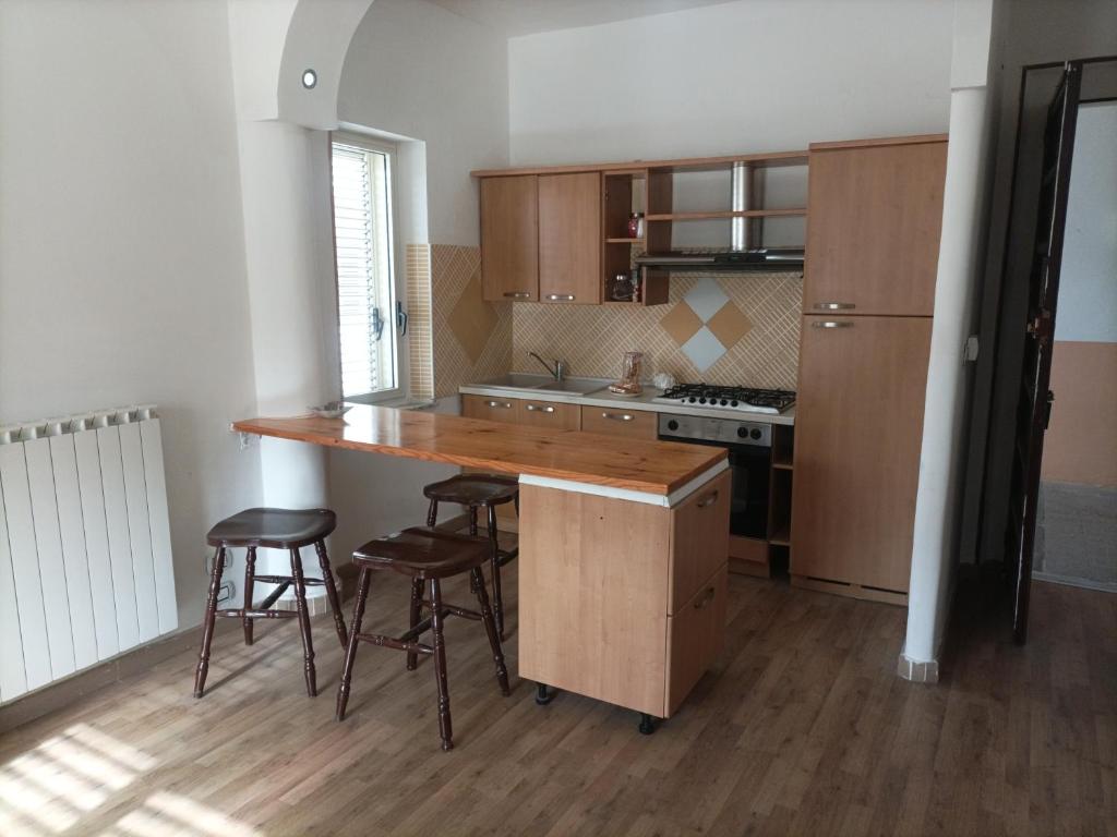 una cucina con bancone in legno e sgabelli di Appartamento in centro a Vibo Valentia