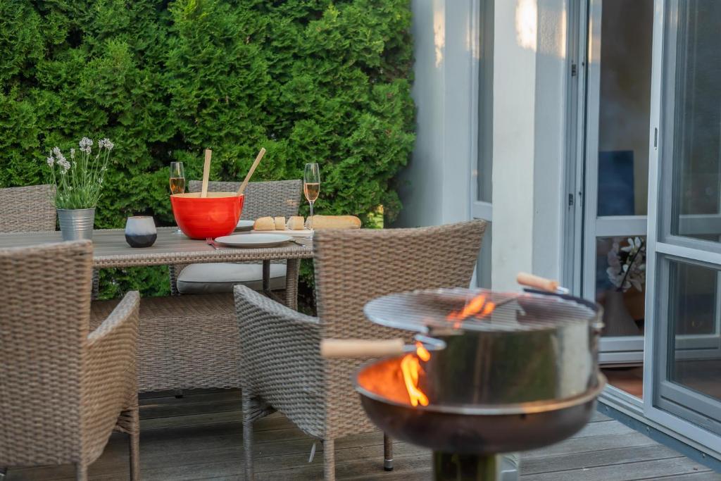 eine Feuerstelle auf einer Terrasse mit einem Tisch und Stühlen in der Unterkunft Ferienhaus an der alten Gärtnerei - Lavendel in Heiligendamm