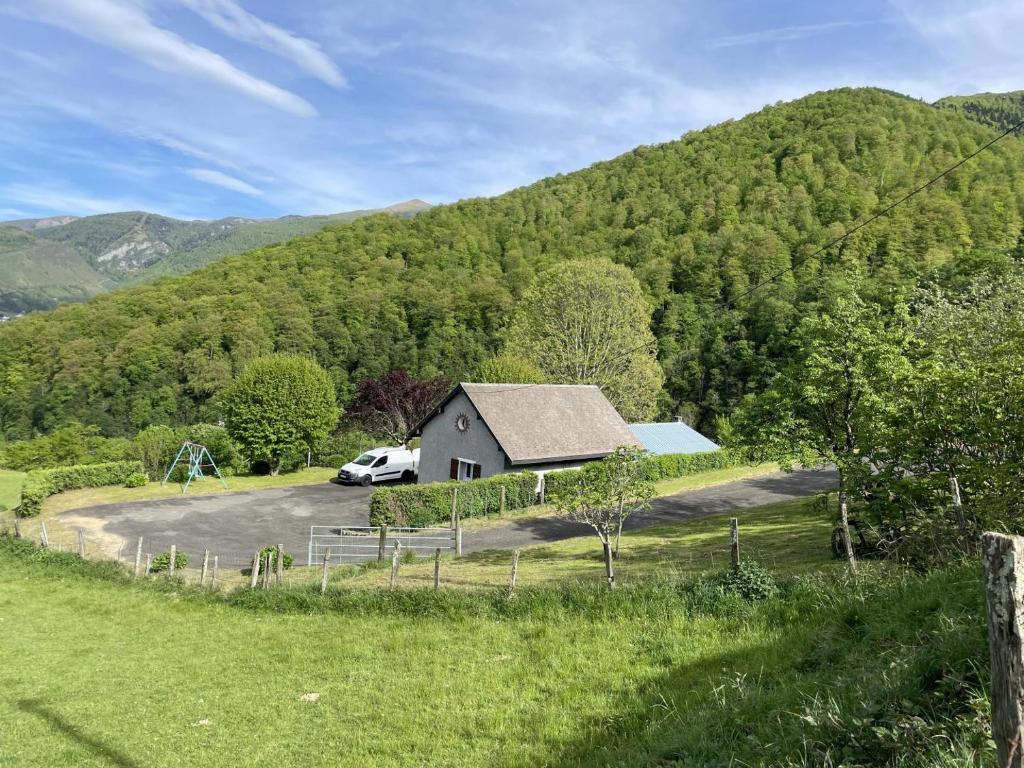 une maison avec une voiture garée devant une montagne dans l'établissement Chuta bas, à Sainte Engrace