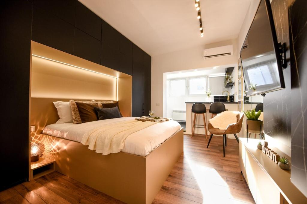 a bedroom with a large bed and a dining room at Calea Victoriei Modern Studio - Escape in the City Center in Bucharest