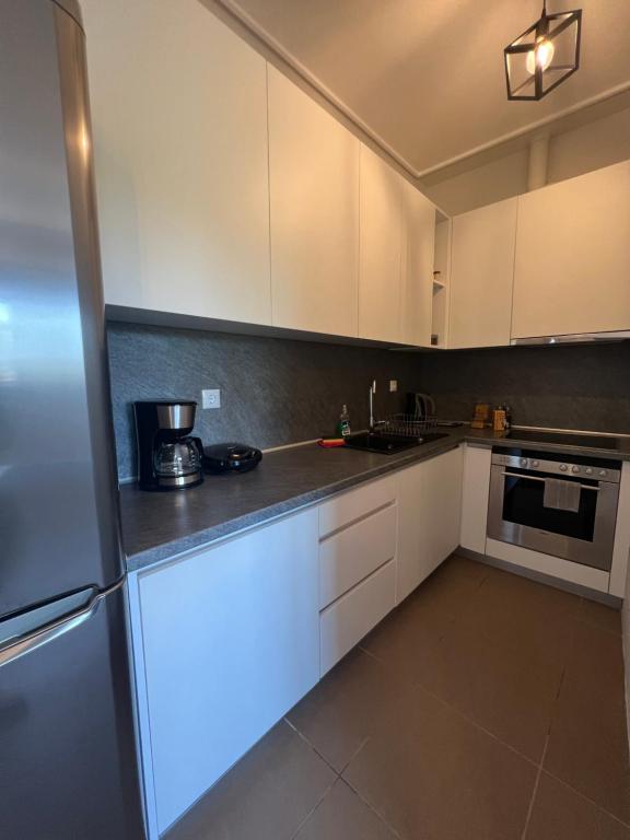 a kitchen with white cabinets and a refrigerator at EVa's Luxury Apartments No 1 in Áyios Spirídhon