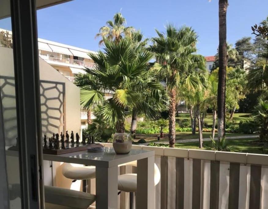 d'une table et de chaises sur un balcon avec des palmiers. dans l'établissement La Petite Suite, à Cannes