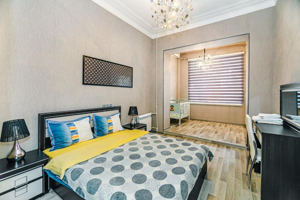 um quarto com uma cama, uma secretária e uma televisão em Seaside Apartments em Baku