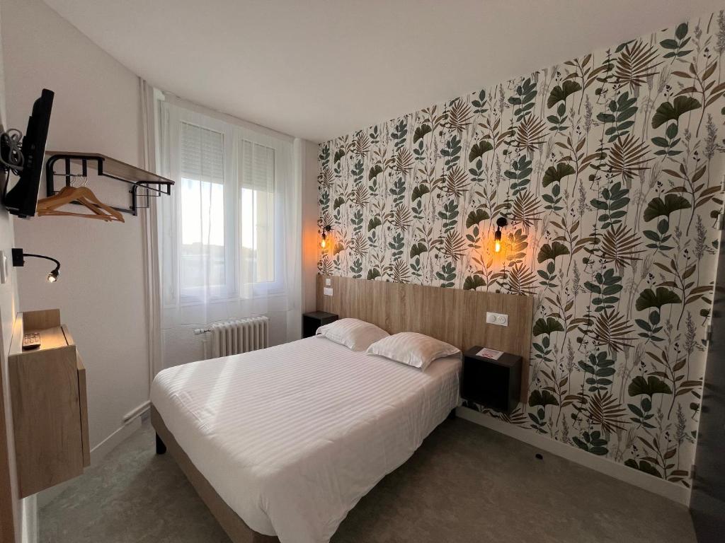 洛里昂的住宿－Hôtel Le Keroman，一间小卧室,配有一张床和图案墙