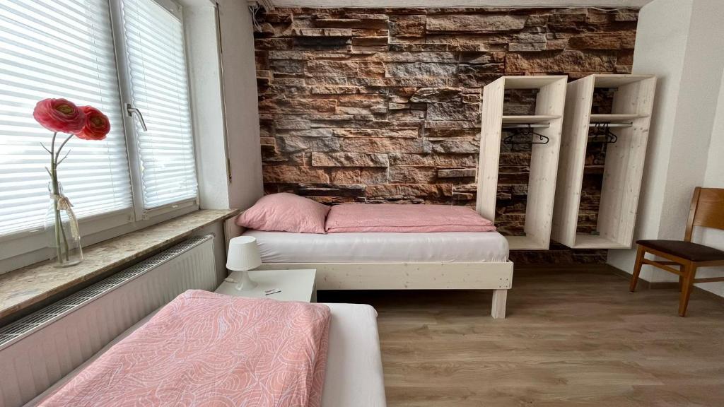 a bedroom with two beds and a brick wall at Pension Highway 3 - Preußisch Oldendorf Goethestraße 6 in Preußisch Oldendorf