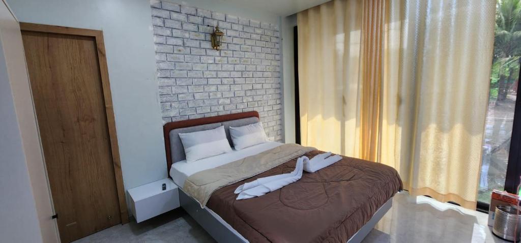 1 dormitorio con 1 cama con toallas en Riverside Farm, en Murud