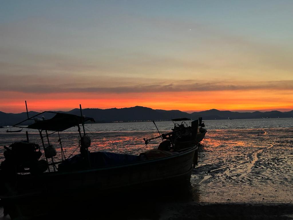 dois barcos sentados na praia ao pôr do sol em 2 Bed Sunset Seaview Good View House Y em Ko Yao Noi