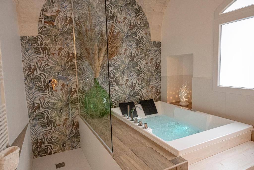 ein Badezimmer mit einer Badewanne mit einer Wand in der Unterkunft Dimore Piazza Vecchia in Castellana Grotte