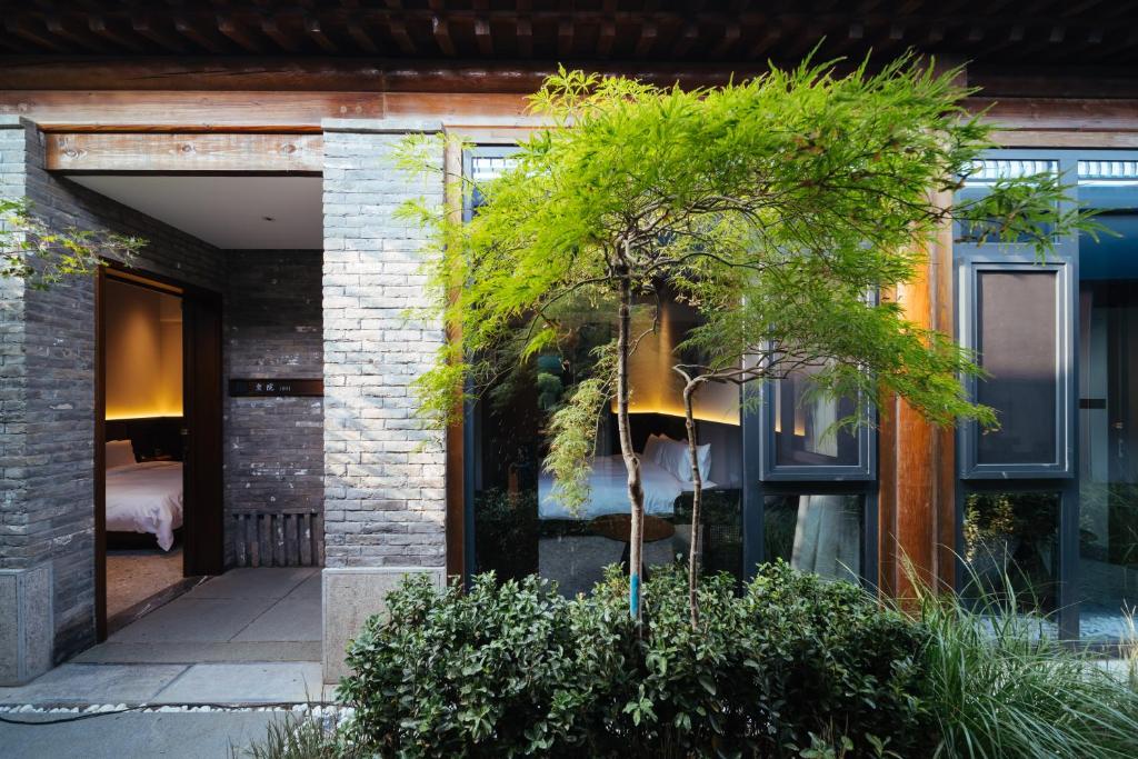 a house with a tree in front of a building at Jingmao Alley Hotel Beijing Wangfujing Dongsi Subway Station Branch in Beijing