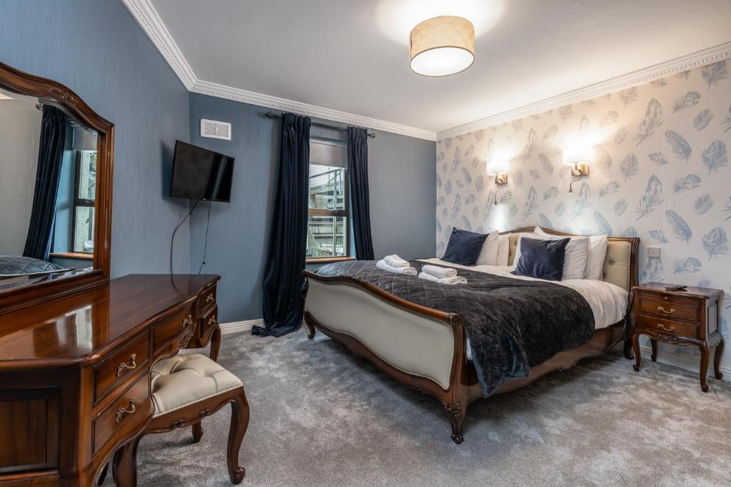Schlafzimmer mit einem Bett, einer Kommode und einem Spiegel in der Unterkunft Troysgate House in Kilkenny
